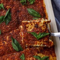 Freshly baked homemade lasagna with melted cheese, rich tomato sauce, and fresh basil garnishes. Perfect comfort food recipe.