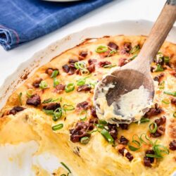 Creamy baked potato casserole topped with bacon and green onions.