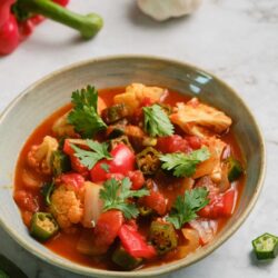 Fresh vegetable minestrone soup in a bowl with herbs and colorful veggies.