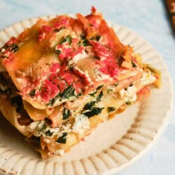 Savory vegetable and cheese lasagna baked in a ceramic dish, perfect for family dinners.