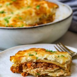 Creamy lasagna with ground beef and melted cheese in a baking dish.