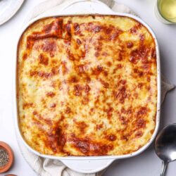 Creamy baked cheesy lasagna with golden brown top. Perfect comfort food recipe from Baked Bree.