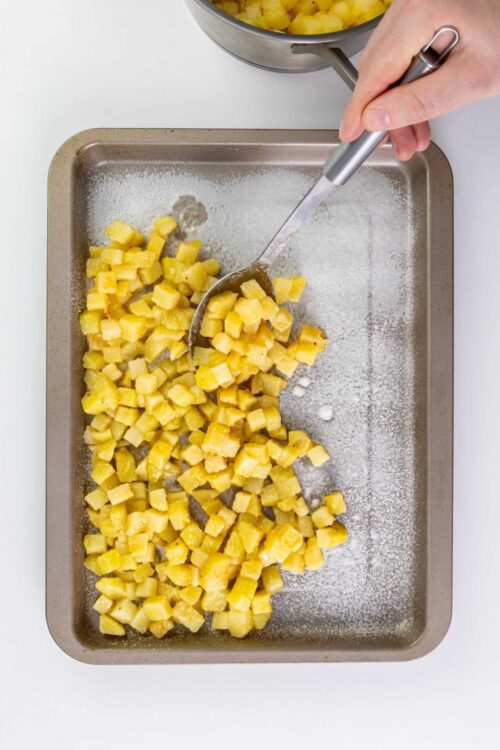 Freshly diced pineapple on a baking sheet for pineapple desserts or snacks.