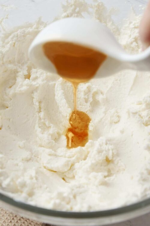 Butter being poured into a bowl of whipped cream or frosting.