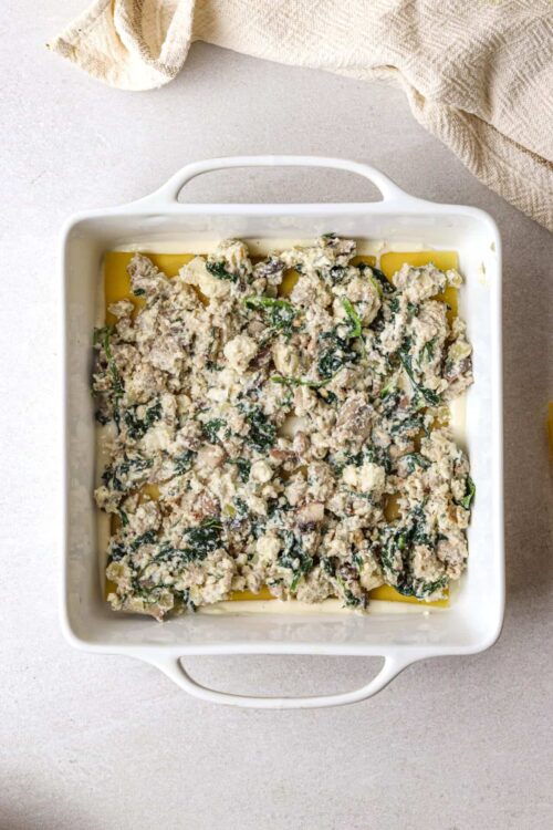 Savory chicken and spinach casserole in a white baking dish.