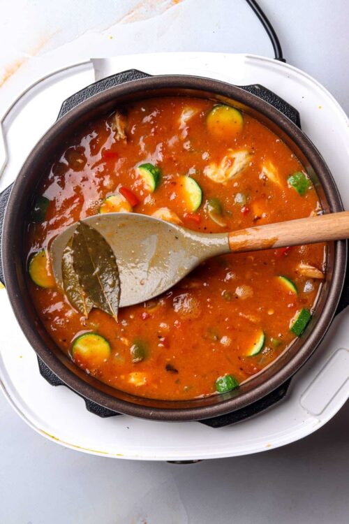 Savory vegetable soup in a skillet with zucchini, tomatoes, and herbs.