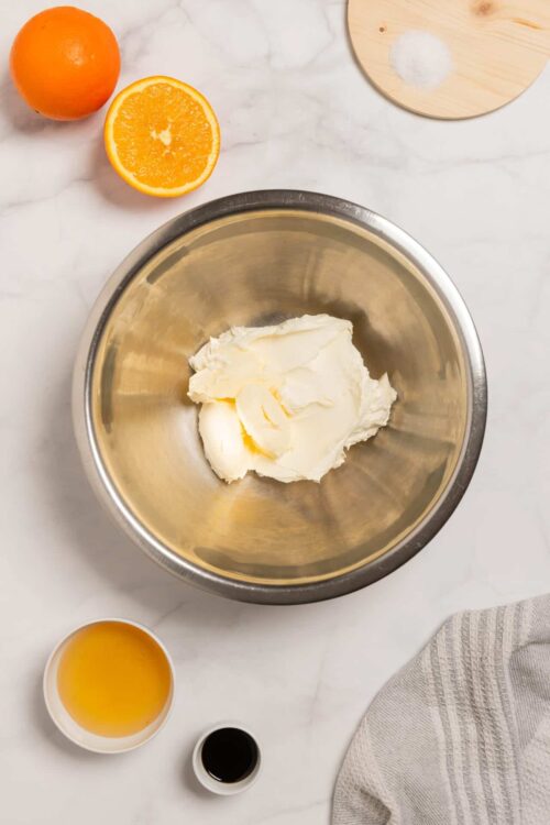 Cream cheese in stainless steel mixing bowl for baking dessert.