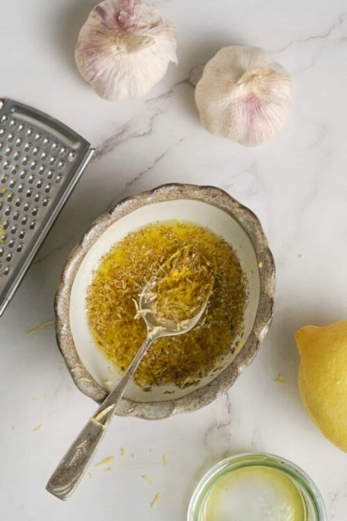 Minced garlic and herbs in a bowl for cooking or seasoning.