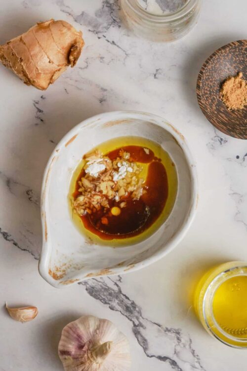 Creamy garlic and ginger marinade ingredients in a small bowl for flavorful cooking.
