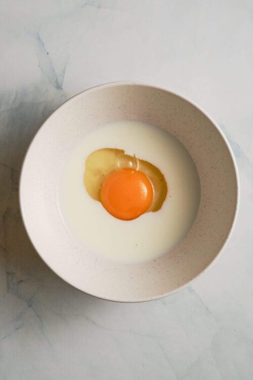 Fresh raw egg in a white bowl, ideal for baking and cooking.