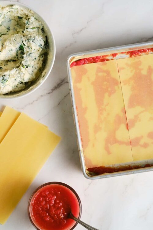 Cream cheese spinach filling for homemade lasagna in a baking dish.