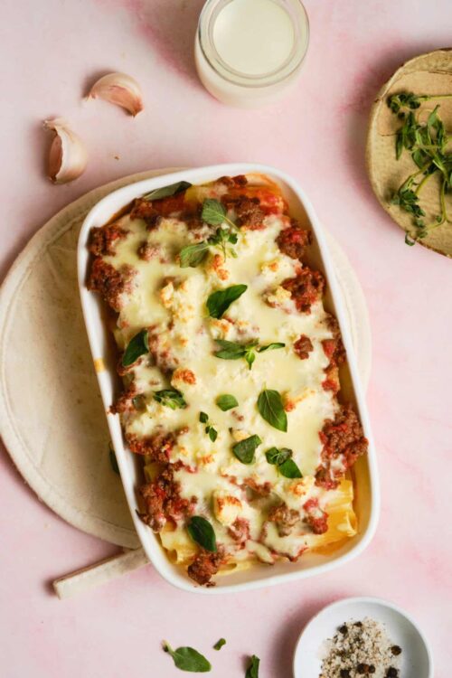 Golden baked lasagna with melted cheese and fresh basil on top.