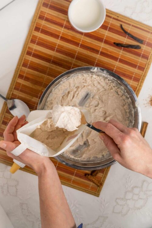 Filling cookie dough into a piping bag for baking or decorating.