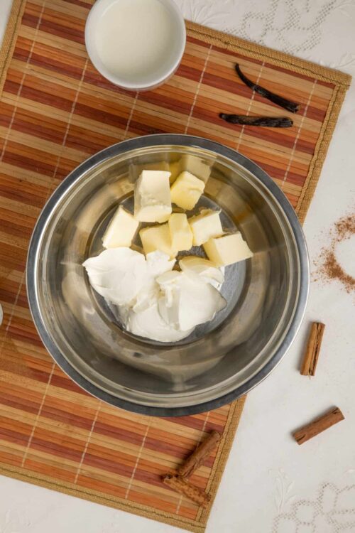 Cream cheese and butter in a stainless steel mixing bowl, ready for baking or cooking.