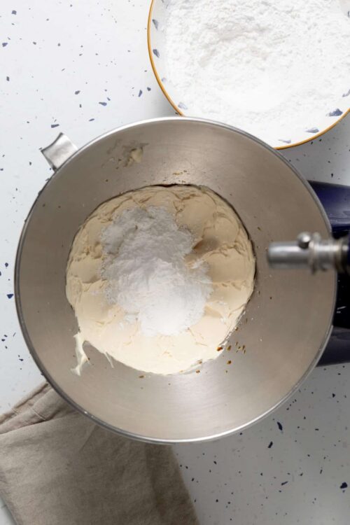 Cream cheese and powdered sugar in mixing bowl for baking recipes.
