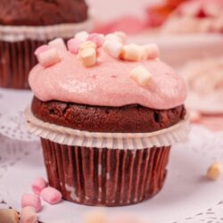 Rich chocolate cupcake with pink frosting and mini marshmallows, perfect for baking and dessert recipes.