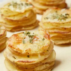 Golden baked potato stacks with cheese and herbs, ready to serve.