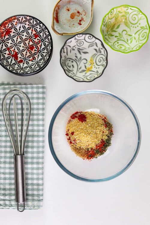 Ground spices and herbs in a glass mixing bowl for baking or cooking.
