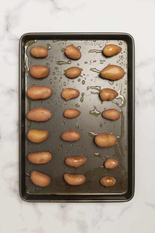 Roasted fingerling potatoes on baking sheet.