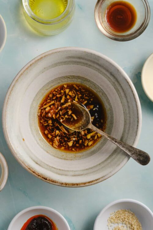 Minced garlic and soy sauce in a gray bowl for Asian cooking.