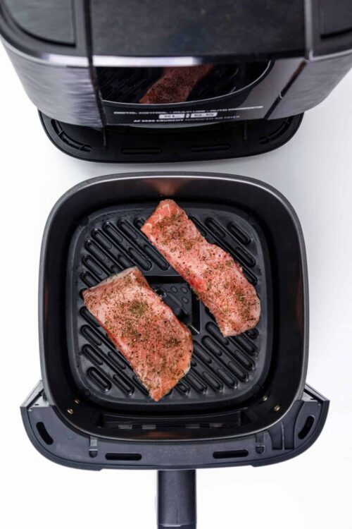 Juicy seasoned steaks cooking in an air fryer for easy meal prep. Perfect for grilling or quick dinner ideas.