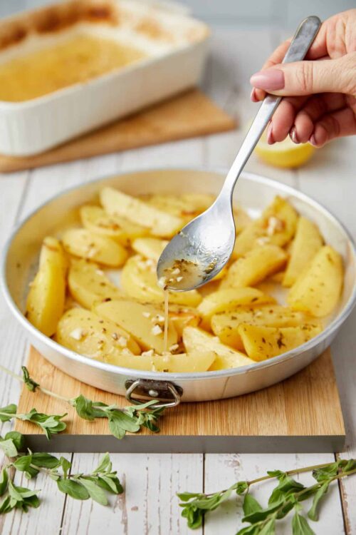 Buttered potatoes with garlic and herbs in a skillet.