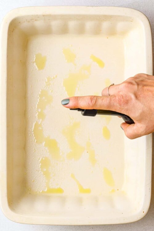 Buttered baking dish with oil spots, ready for baking or cooking.