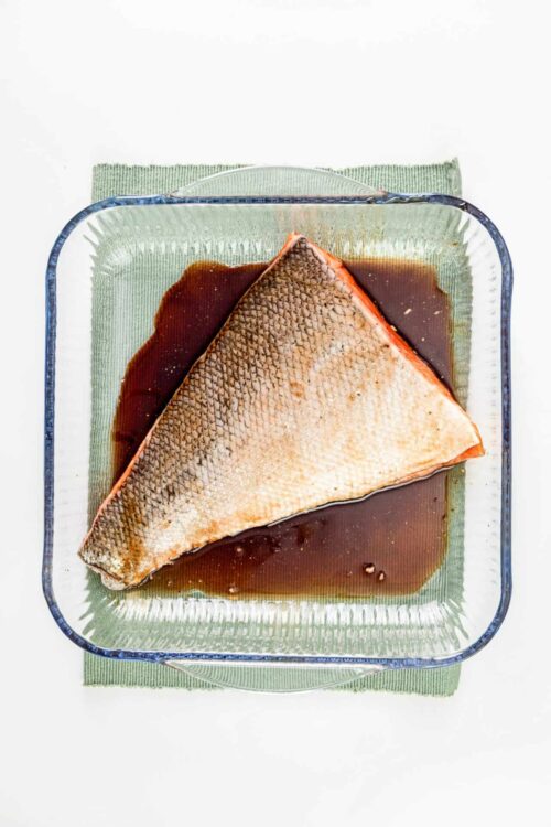 Baked salmon fillet with soy sauce in a glass dish.