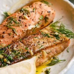 Fresh baked salmon with herbs and lemon slices, perfect for healthy dinners.