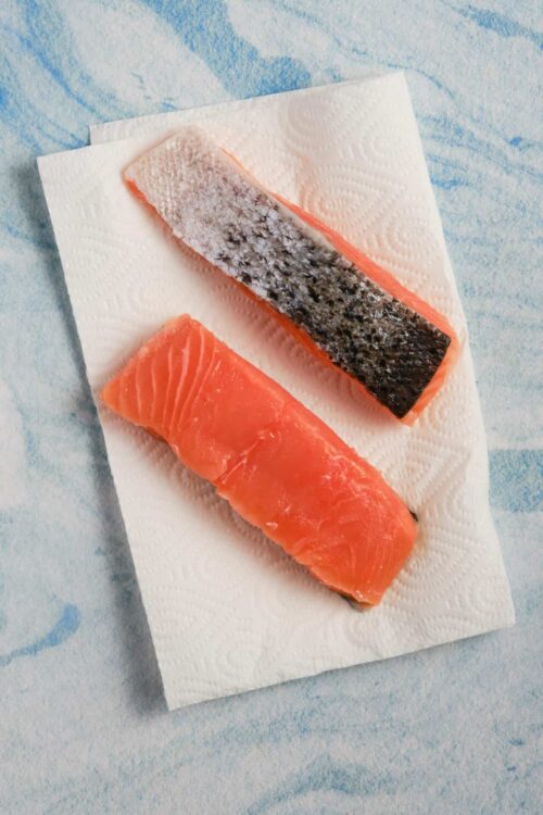 Fresh raw salmon fillets on paper towels, ready for cooking or baking.