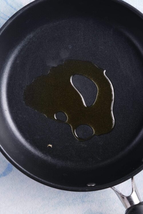 Olive oil in non-stick frying pan for cooking or sautéing.