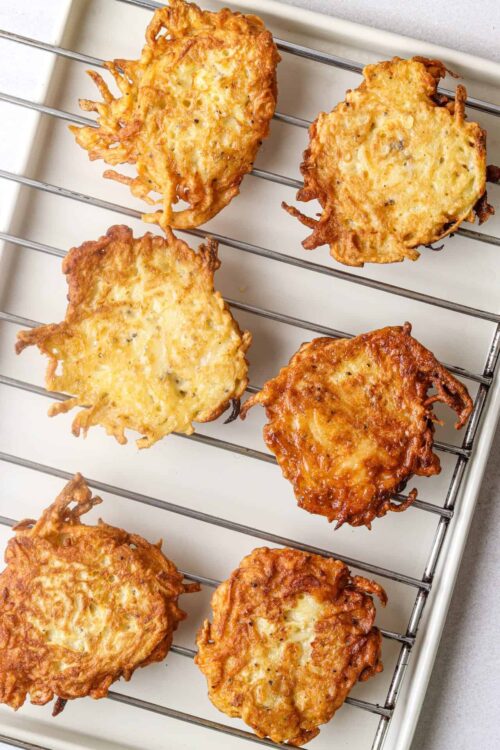 Crispy homemade potato pancakes on cooling rack, golden and delicious.