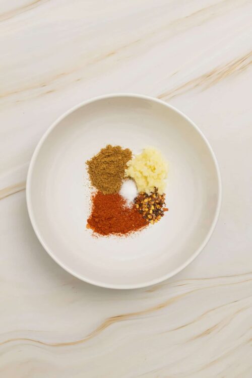 Ground spices and seasonings on a white bowl, ready for baking or cooking.