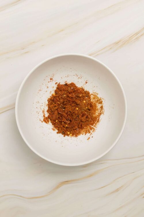 Smoked paprika spice in a white bowl for cooking and seasoning.