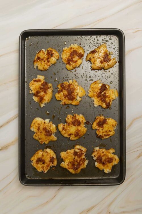 Golden roasted chicken pieces with a crispy, seasoned coating on a baking sheet.