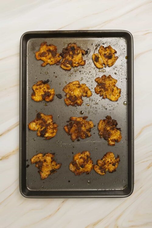Crispy oven-baked cauliflower bites on a baking sheet, perfect for healthy snacks or appetizers.