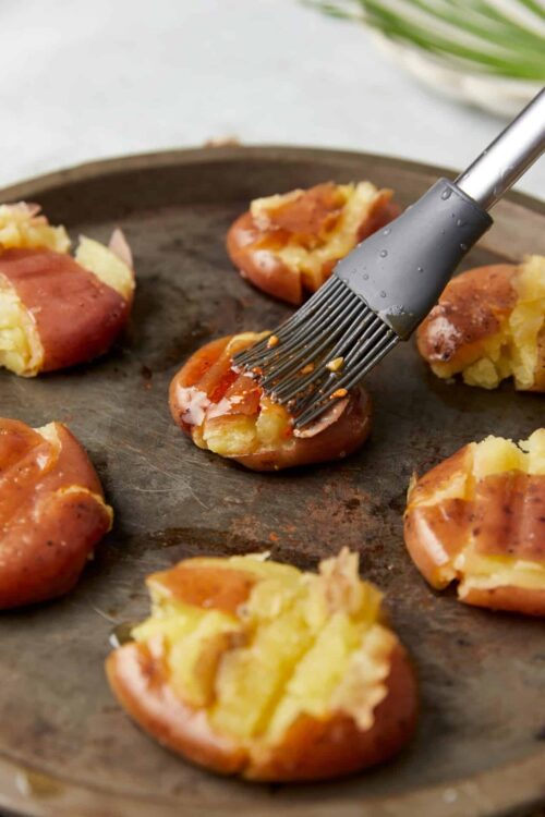 Baked stuffed potatoes with cheese and bacon on a baking sheet.