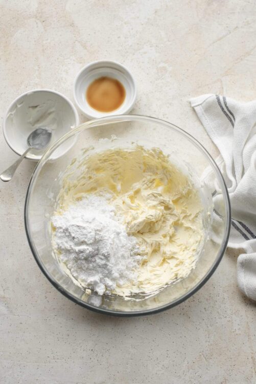 Flour, butter, vanilla extract, and sour cream mixed in a glass bowl for baking.