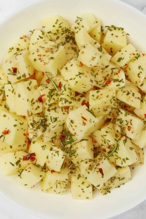 Boiled potatoes with herbs and red pepper flakes for flavorful side dish.