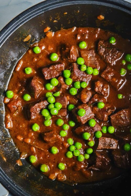 Beef stew with green peas in slow cooker.