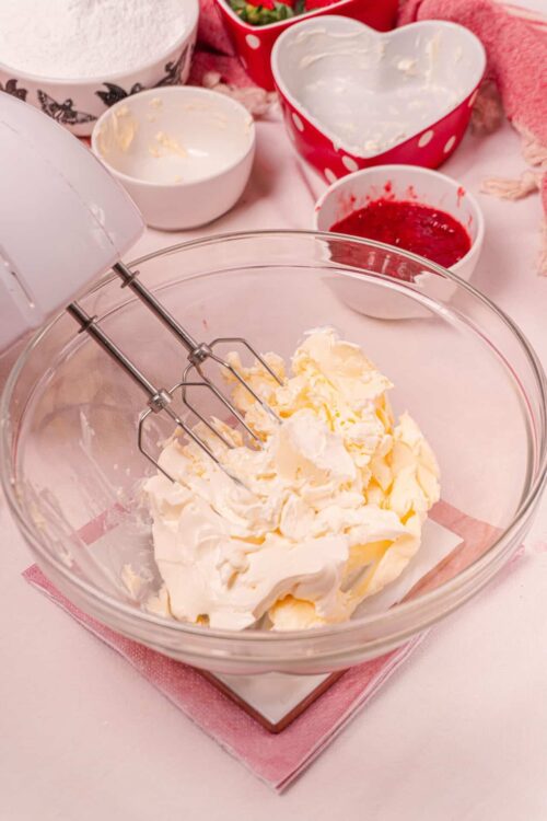 Fluffy cream cheese and butter mixture in a glass bowl for baking recipes.