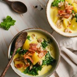 Creamy potato and kale soup with bacon in rustic bowls, perfect comfort food for fall and winter.