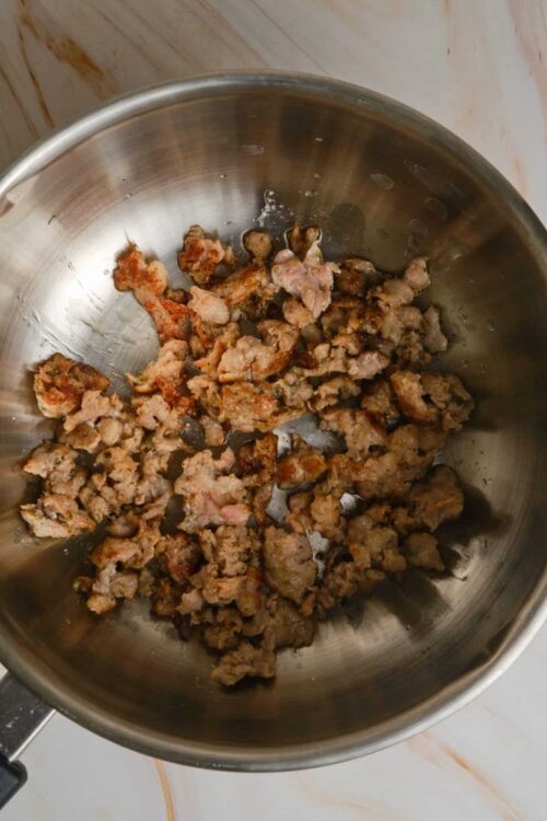 Crispy cooked ground meat in a stainless steel pan.