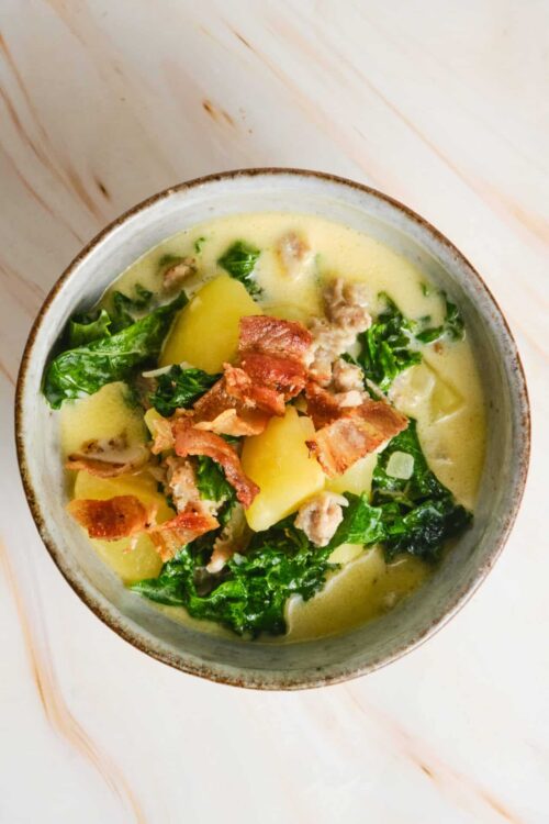 Creamy potato and kale soup topped with crispy bacon. Perfect for cozy comfort food recipes and healthy meal ideas.