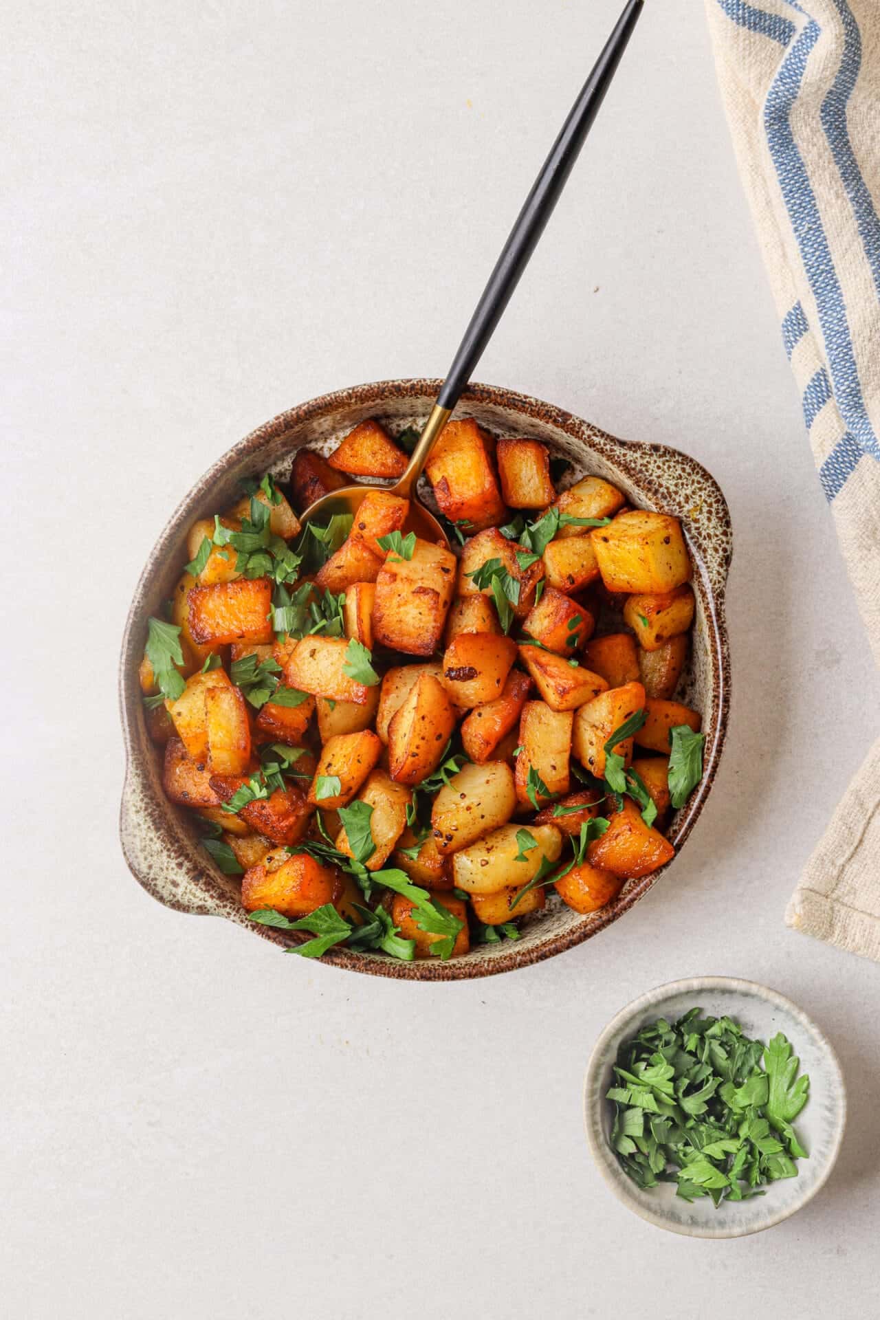 Roasted sweet potatoes with herbs in a rustic bowl for healthy side dishes.