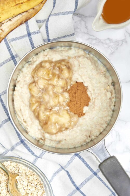 Creamy oatmeal with bananas, cinnamon, and brown sugar, ready for serving or topping.