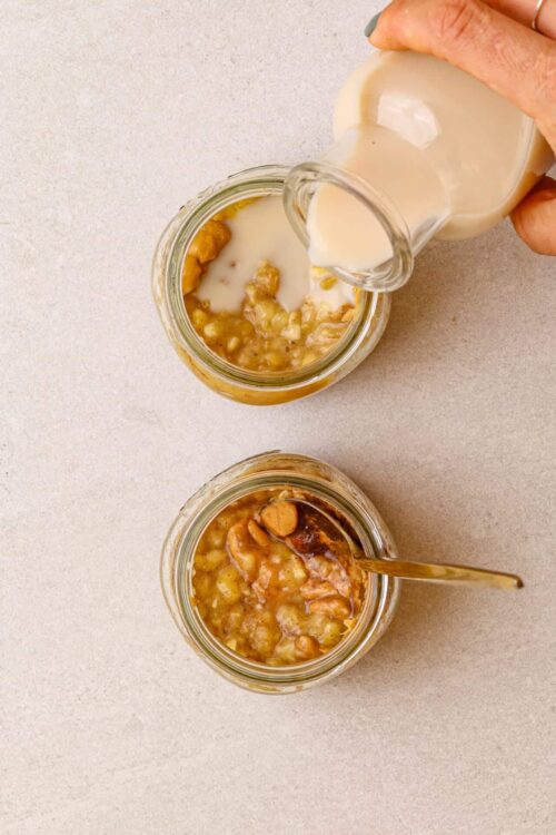 Sweet potato casserole with marshmallows and pecans in jars, topped with cream.