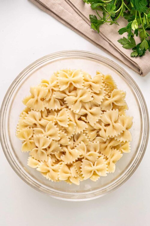 Cooked farfalle pasta in a glass bowl, ready for a delicious recipe.