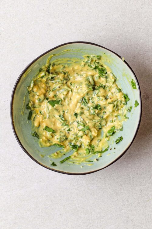 Wilted garlic and herb butter in a light green bowl.