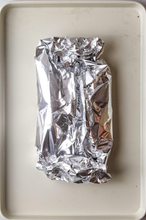 Shiny aluminum foil wrapping on a baking sheet, ready for baking or roasting.